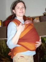 Ukážka nesenia štvortýždňového dieťaťa v šatke. Bábätko má mierne zaguľatený chrbátik, šatka je vytiahnutá až za hlavičku, ktorú zaisťuje.