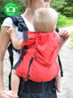 Usadenie dieťaťa v nosítku Kibi Granada - pomocou patentiek je možné veľkostne nastavovať šírku nosiča v sedacej časti - nosič sa tak dokáže pekne prispôsobiť roznoženiu a veku bábätka. 